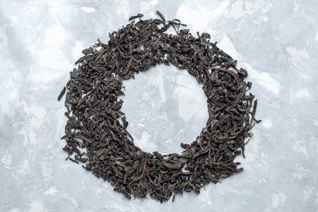 Top view dried tea black colored forming circle on the light table, grain tea dry color