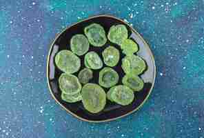 Free photo top view of dry kiwi slices on black plate. close op photo .