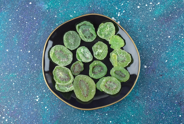 Top view of dry kiwi slices on black plate. Close op photo . 