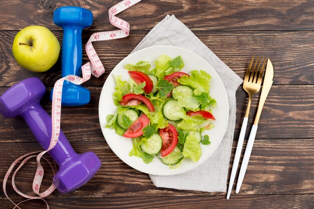 Top view dumbbells with salad