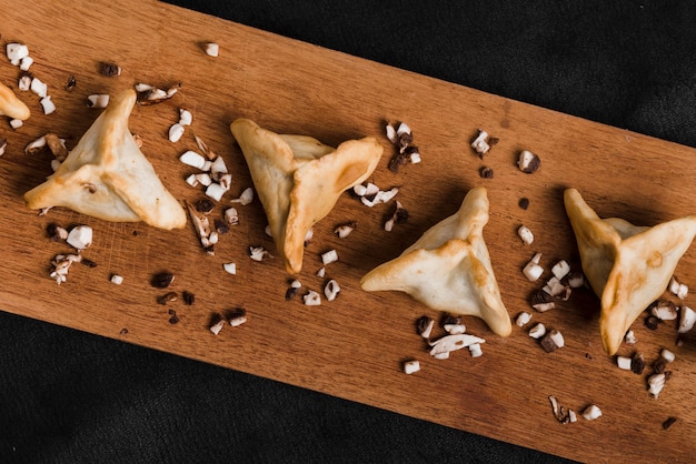 Top view of dumplings on chopping board against black background