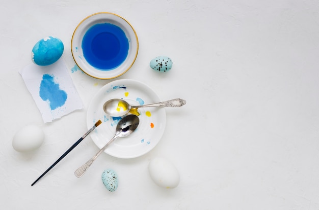 Top view of dye for easter eggs with brush and spoons