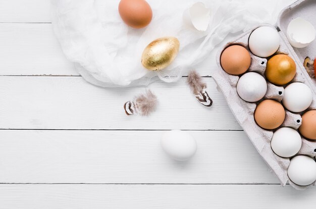 Top view of dyed and simple eggs for easter in carton