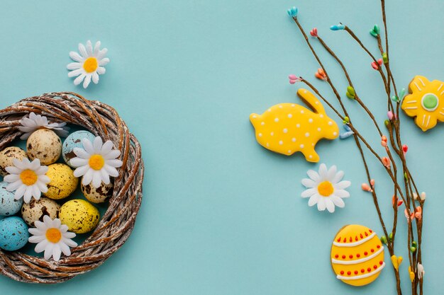 Top view of easter eggs in basket with chamomile flowers