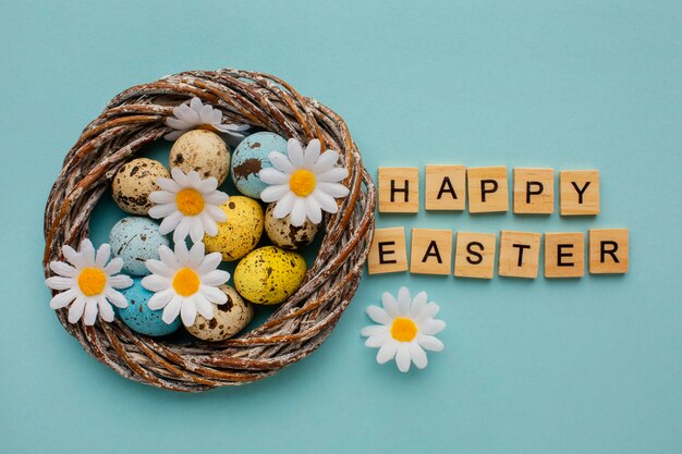 Top view of easter eggs in basket with greeting and chamomile flowers