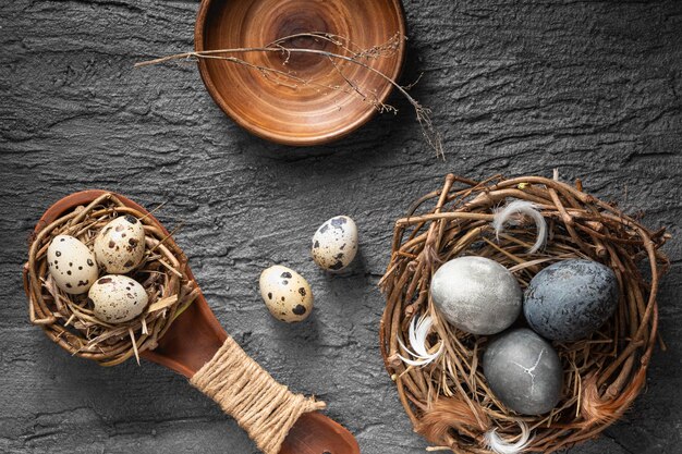 Top view of easter eggs in bird nest and wooden spoon over slate