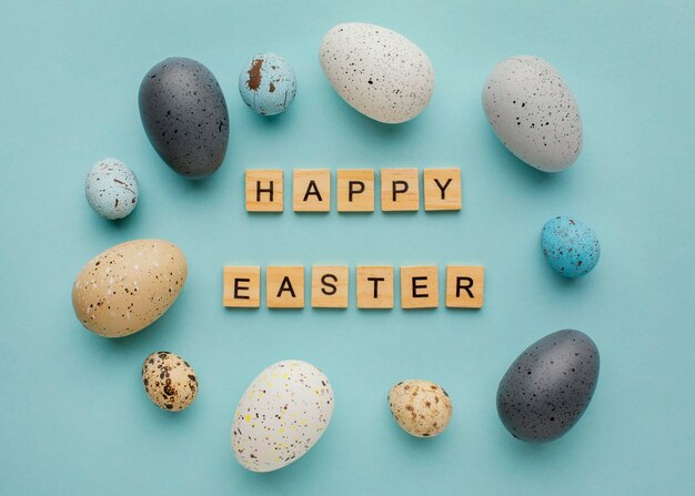 Top view of easter eggs with greeting made of wooden cubes