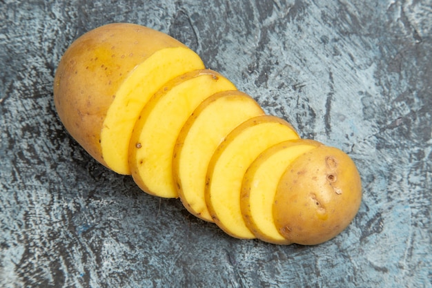 Vista dall'alto di fette di patate con la buccia deliziose facili di sfondo grigio