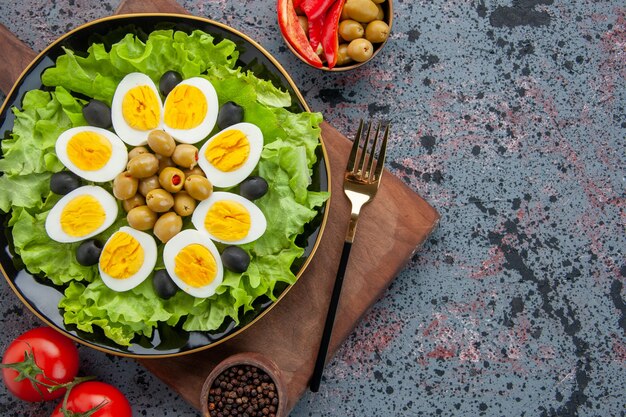 top view egg salad green salad and olives with tomatoes on light background