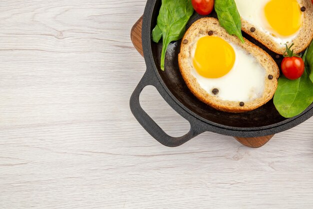 白い背景の上の新鮮な卵と鍋の中の上面図卵トーストパン色ランチ皿食事茶食品