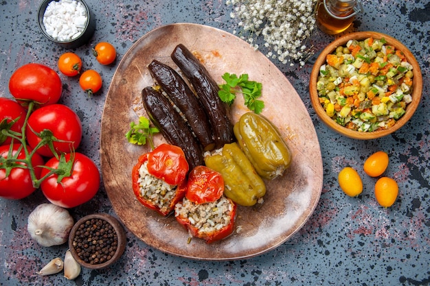 top view eggplant dolma with cooked tomatoes and bell-peppers filled with ground meat inside plate, dish dinner food meal color