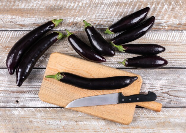 Top view eggplants on cutting board with knife . horizontal