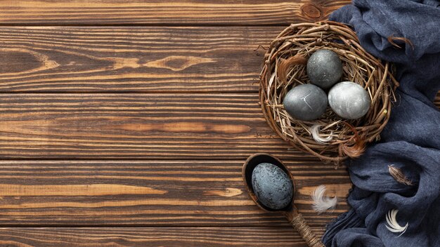 Top view of eggs for easter in bird nest with textile and copy space