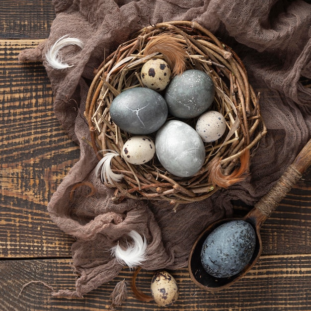 Вид сверху яиц на пасху с текстилем и птичьим гнездом