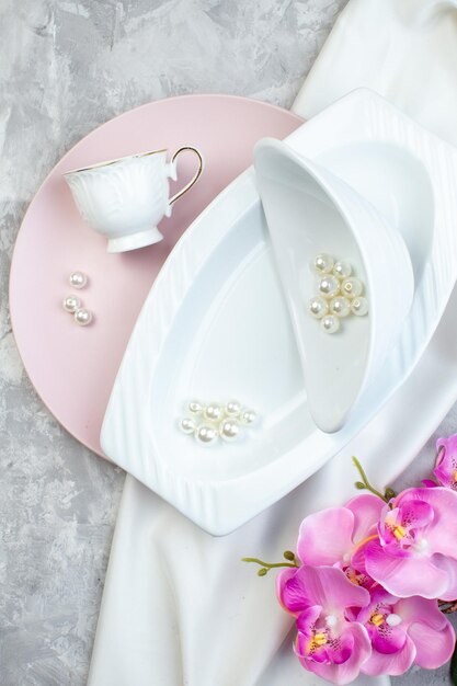 Вид сверху элегантные тарелки с красивыми бусинами на белой поверхности