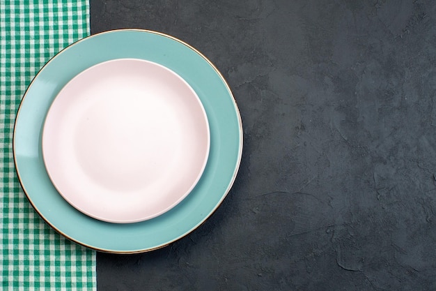 어두운 배경에 파란색 접시가 있는 상위 뷰 우아한 흰색 접시 식당 은제품 여성성 기아 은혜 화려한