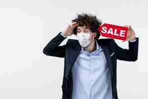 Free photo top view of emotional confused business person in suit and wearing his mask showing sale inscription on white background