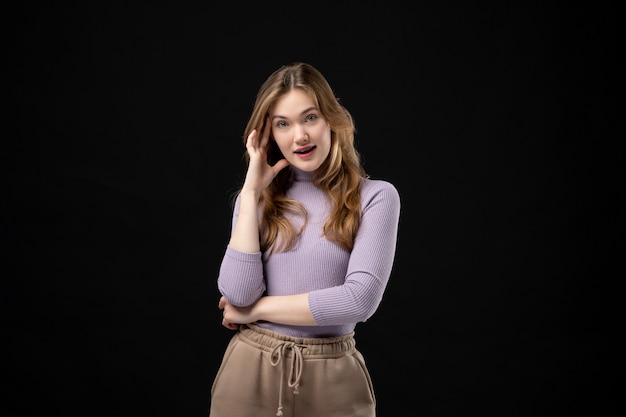 Top view of emotional and positive concentrated girl posing for camera on dark