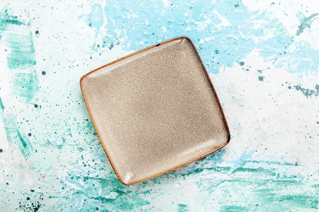 Free photo top view empty brown plate square formed on blue background kitchen food plate cutlery