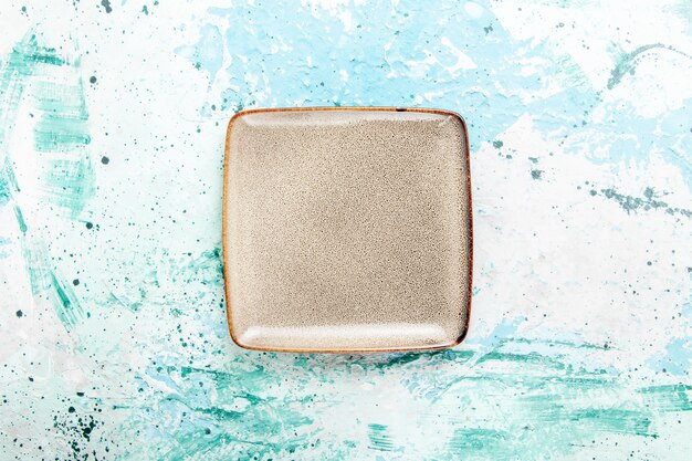 Top view empty brown plate square formed on light blue background kitchen food plate cutlery