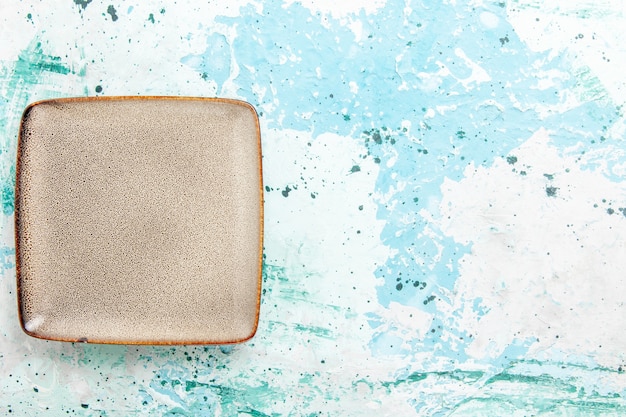 Top view empty brown plate square formed on light-blue desk kitchen food plate cutlery