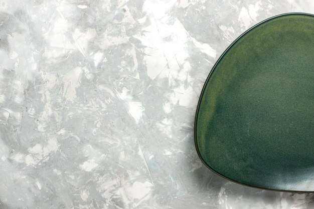 밝은 회색 책상에 고립 된 상위 뷰 빈 녹색 접시.