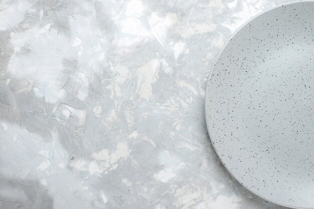 Top view of empty grey plate on light, plate kitchen cutlery