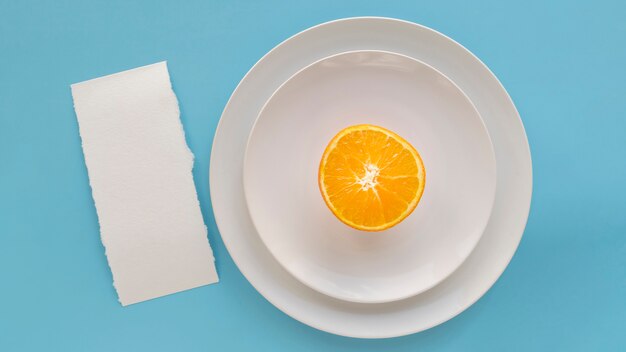 Вид сверху пустой меню бумаги с тарелками и апельсином