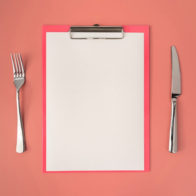 Top view of empty menu with cutlery