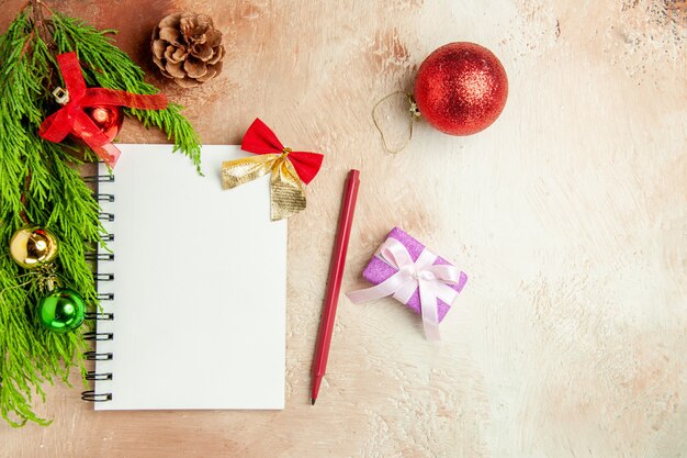 Top view empty open notepad with green branch and toys