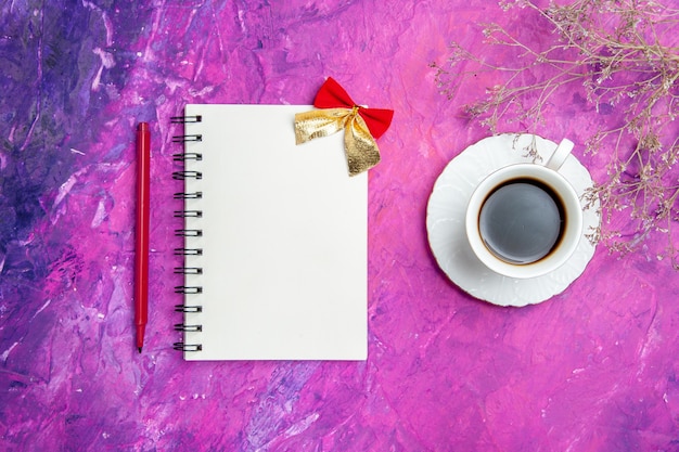 Top view empty open notepad with red pencil and cup of tea