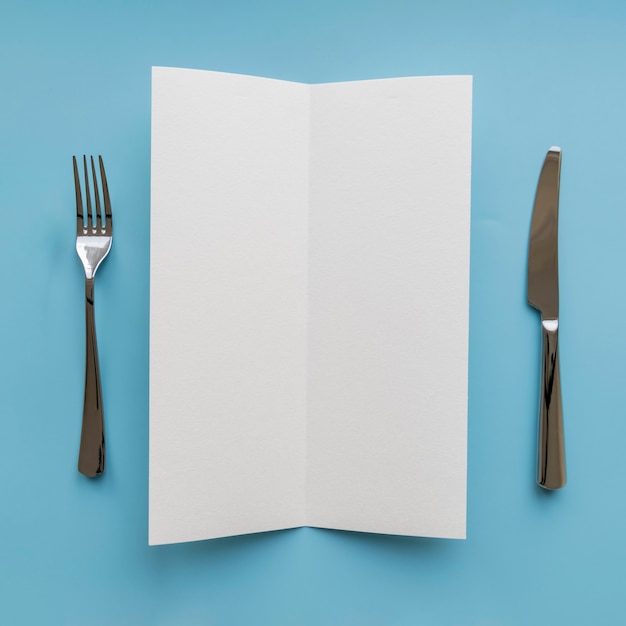 Top view of empty paper with fork and knife