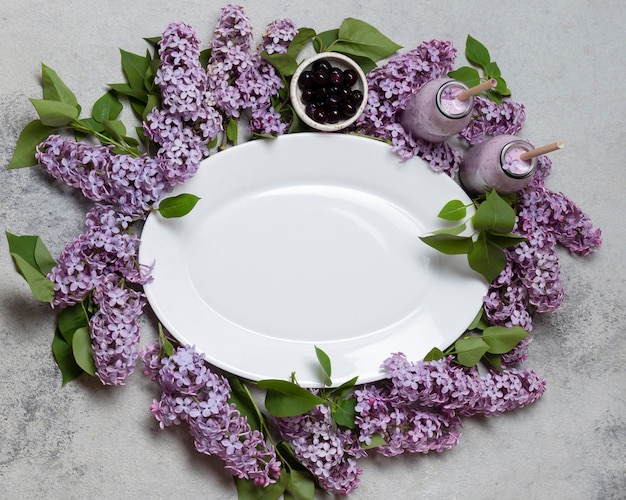 Top view empty plate over hyacinth flowers with smoothie