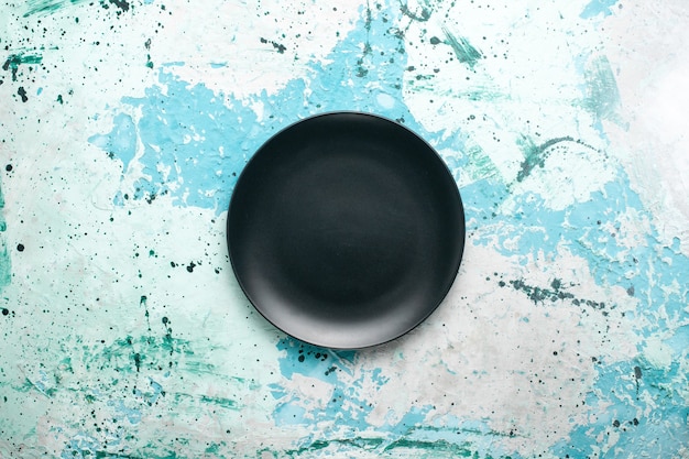 Вид сверху пустая круглая тарелка темного цвета на синем фоне цветная тарелка кухонные столовые приборы стакан