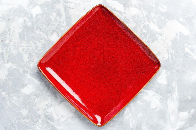Top view empty square plate red ed on white surface