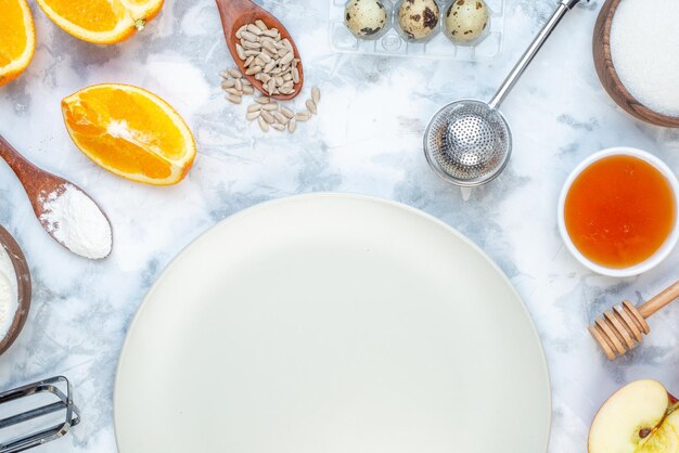 Вид сверху пустой белой тарелки и свежей здоровой пищи на двухцветной поверхности