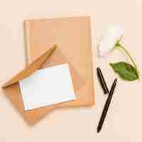 Free photo top view of envelope, flower and book