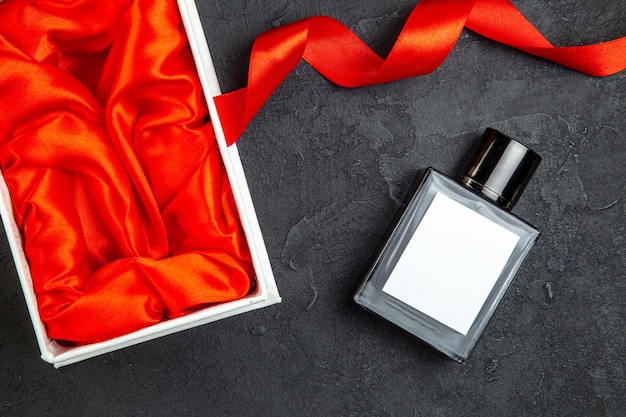 Free photo top view expensive perfume in elegant package as a present on dark table