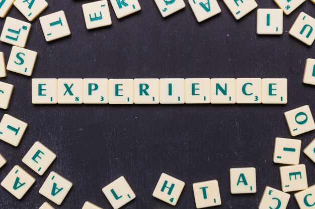 Top view of experience text with scrabble letters over black backdrop