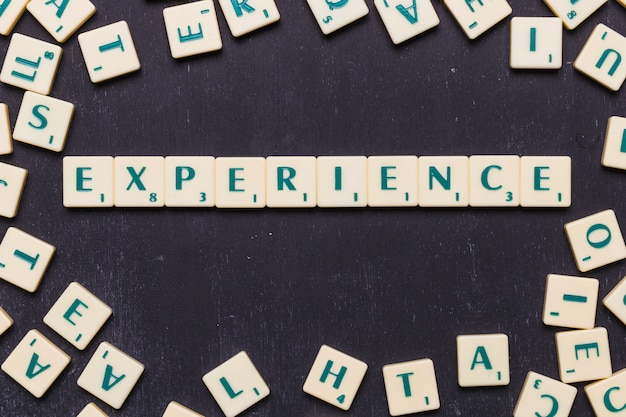top view of experience text with scrabble letters over black backdrop
