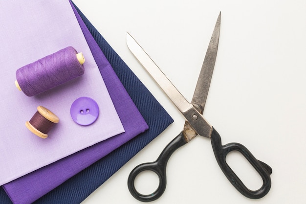 Top view of fabrics with scissors and button