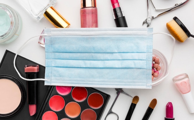 Top view face mask surrounded by beauty products