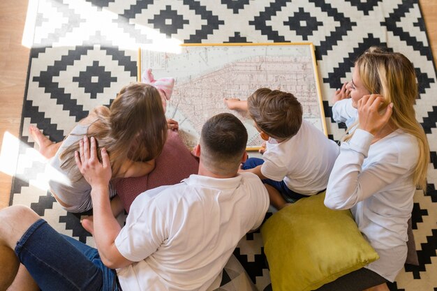 Top view family indoors looking at a blue print
