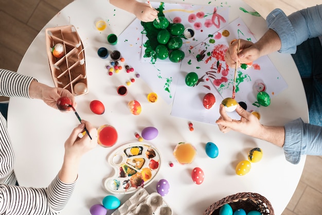 Top view family painting eggs for easter