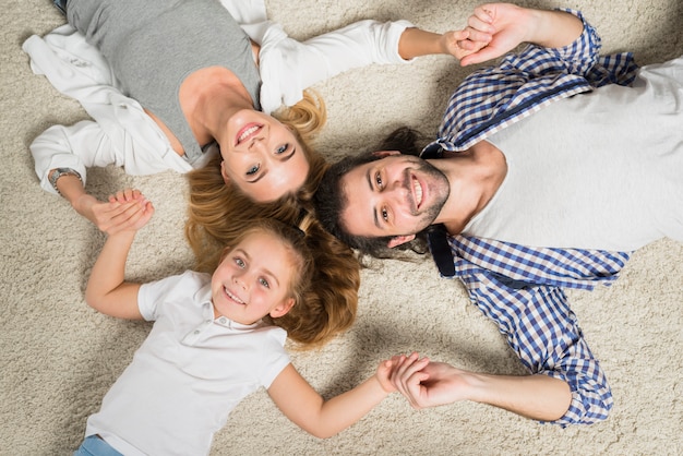 Вид сверху портрет семьи, лежащий на ковре