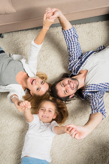 Вид сверху портрет семьи, лежащий на ковре