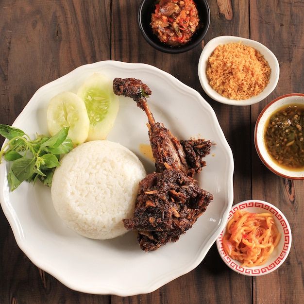 Premium Photo Top View Famous Food In Madura Indonesia Called Bebek Sinjay Bebek Is Duck Consisting Of Rice Duck Cucumber Basil And Young Mango Chilli