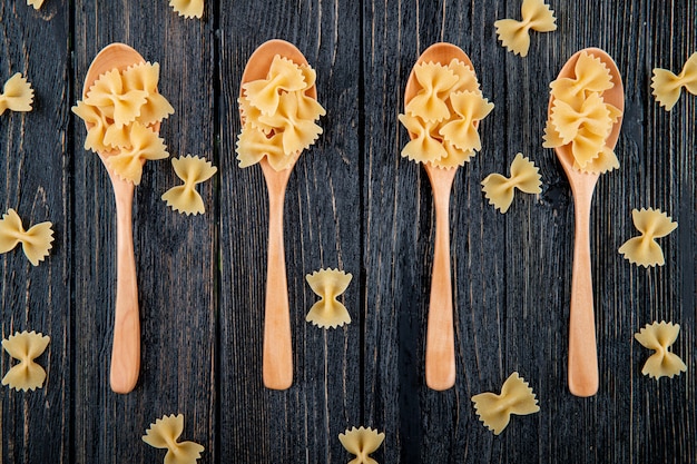 Top view farfalle pasta on black wooden background