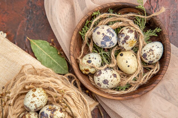 Top view of farm fresh eggs on a roll of rope on bag and on a pot on a brown table