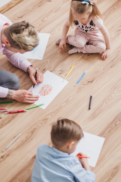 Top view of father drawing with his children